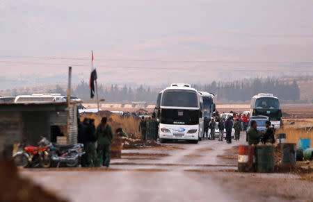 Rebels and civilians are seen next to coaches in which they will be evacuated, in Beit Jann, Syria December 29, 2017. REUTERS/Omar Sanadiki
