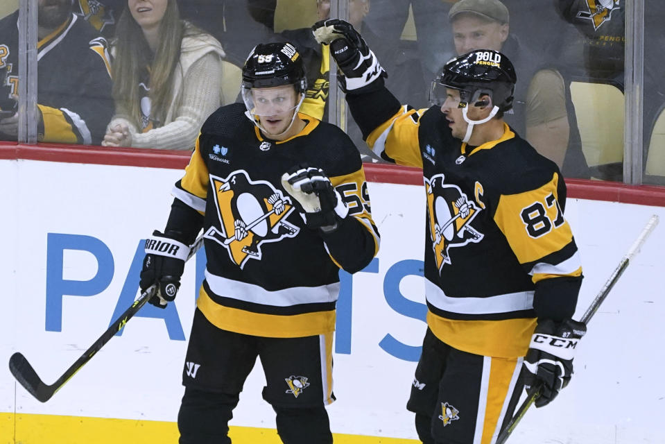 Pittsburgh Penguins' Jake Guentzel (59) is congratulated by Sidney Crosby after scoring against the Buffalo Sabres during the first period of an NHL preseason hockey game Friday, Oct. 7, 2022, in Pittsburgh. (AP Photo/Keith Srakocic)