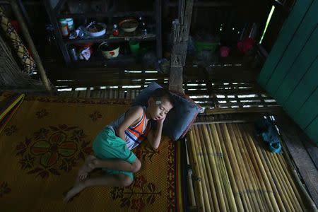 A boy feeling unwell rests in his home at Kanhla village, an area to be included in the New City Project, outside Yangon August 30, 2014. REUTRS/Soe Zeya Tun