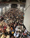 FILE - Afghan citizens pack inside a U.S. Air Force C-17 Globemaster III, as they are transported from Hamid Karzai International Airport in Afghanistan, on Aug. 15, 2021. America’s two-decade war and reconstruction effort in Afghanistan, which cost thousands of U.S. and Afghan lives and billions of dollars, ended in chaos and more death in August. As the remaining American troops were evacuated and those who had aided them desperately sought a way out, there were flashbacks to the fall of Saigon in 1975. (Capt. Chris Herbert/U.S. Air Force via AP, File)