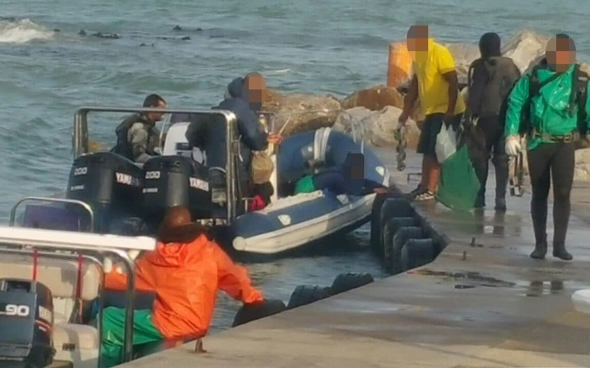 Suspected poachers being driven to a beach