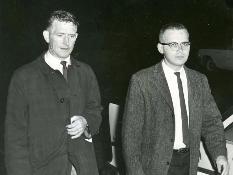 Juris Slesers, the son of Anna Slesers, accompanied by a detective after he found his mother's body in 1962.