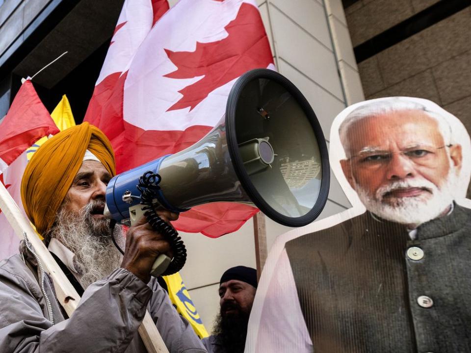  A Sikh protester yells into a megaphone beside an image of Indian Prime Minister Narendra Modi out front of the Indian Consulate in Toronto, on Sept. 25.