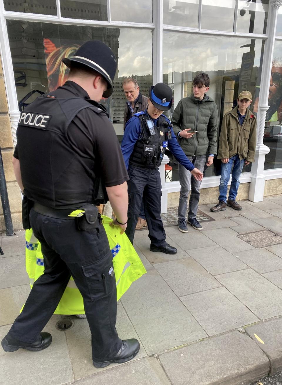 A police officer and two community support officers guide a lost swan back to the river near Pulteney bridge in Bath (Simon Galloway / SWNS)