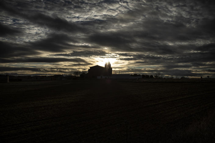 The 16th century Church of San Cristóbal is silhouetted at sunset in Riego del Camino, in the Zamora province of Spain, on Sunday, Nov. 28, 2021. The church has been closed for several years due to the roof's state of ruin, and Sunday Mass is now held on the outskirts of the village. (AP Photo/Manu Brabo)