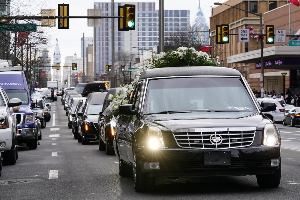 The funeral procession for the victims of a deadly row house fire drives to the century, in Philadelphia, Monday, Jan. 17, 2022. Officials say it was the city's deadliest single fire in at least a century. (AP Photo/Matt Rourke)