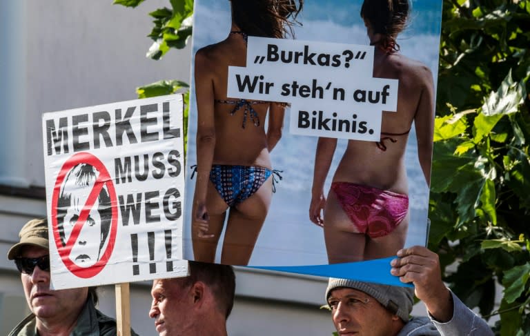 Members of the far-right Alternative for Germany (AfD) party display anti-Merkel placards as the German chancellor arrived for an election rally at her constituency's Baltic Sea resort of Binz