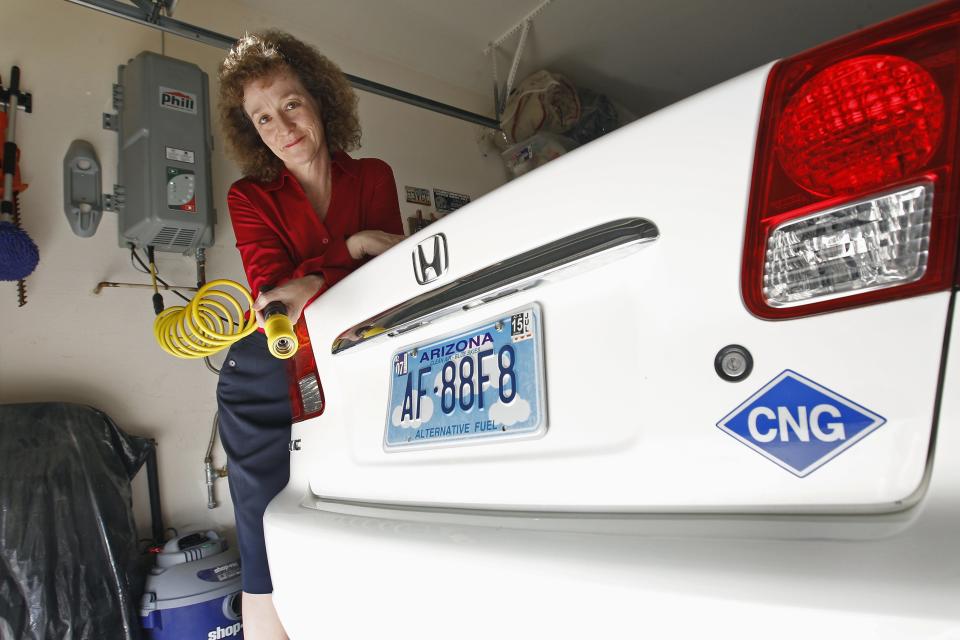 Connie Jones with her 2003 natural gas powered Honda Civic and natural gas home refueling station located on the garage wall of her home in Chandler, Arizona, October 3, 2013. (REUTERS/Ralph D. Freso)