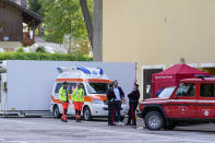 Carabinieri police officers and rescuers stand by the refrigerated container where the bodies of the people who died under the Punta Rocca glacier avalanche are kept in Canazei, in the Italian Alps in northern Italy, Monday, July 4, 2022, a day after a huge chunk of the glacier broke loose, sending an avalanche of ice, snow, and rocks onto hikers. Rescuers said conditions downslope from the glacier, which has been melting for decades, were still too unstable to immediately send rescuers and dogs into the area to look for others buried under tons of debris. (AP Photo/Luca Bruno)
