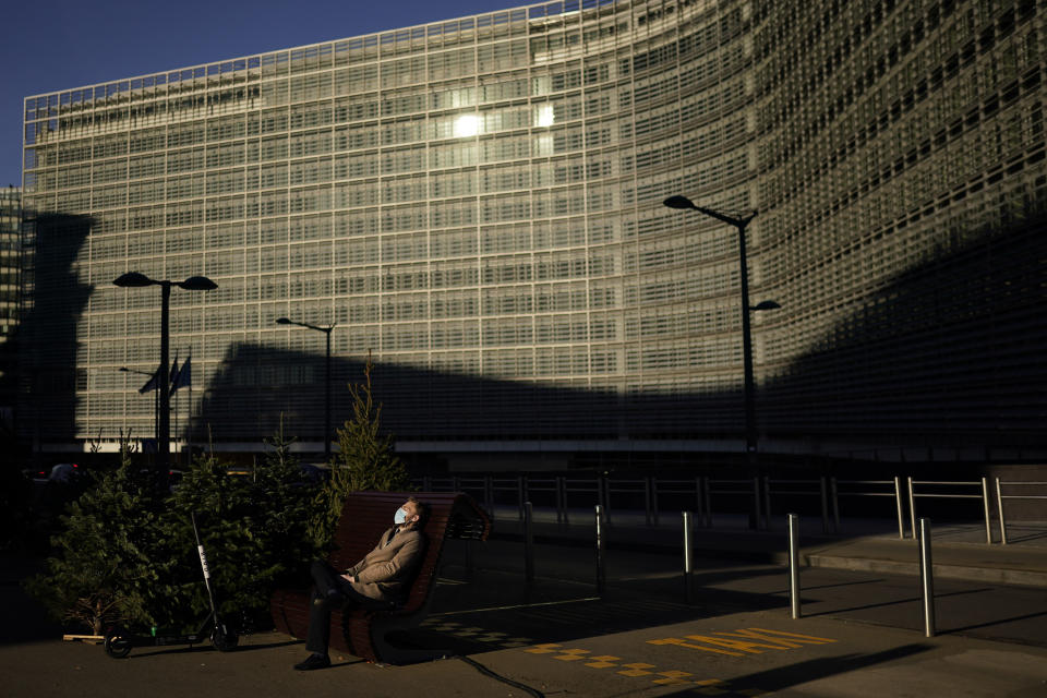 A man sits in a bench under the sun outside the EU headquarters in Brussels, Friday, Dec. 18, 2020. European Commission's Head of Task Force for Relations with the United Kingdom Michel Barnier said that the bloc and the United Kingdom were starting a "last attempt" to clinch a post-Brexit trade deal, with EU fishing rights in British waters the most notable remaining obstacle to avoid a chaotic and costly changeover on New Year. (AP Photo/Francisco Seco)