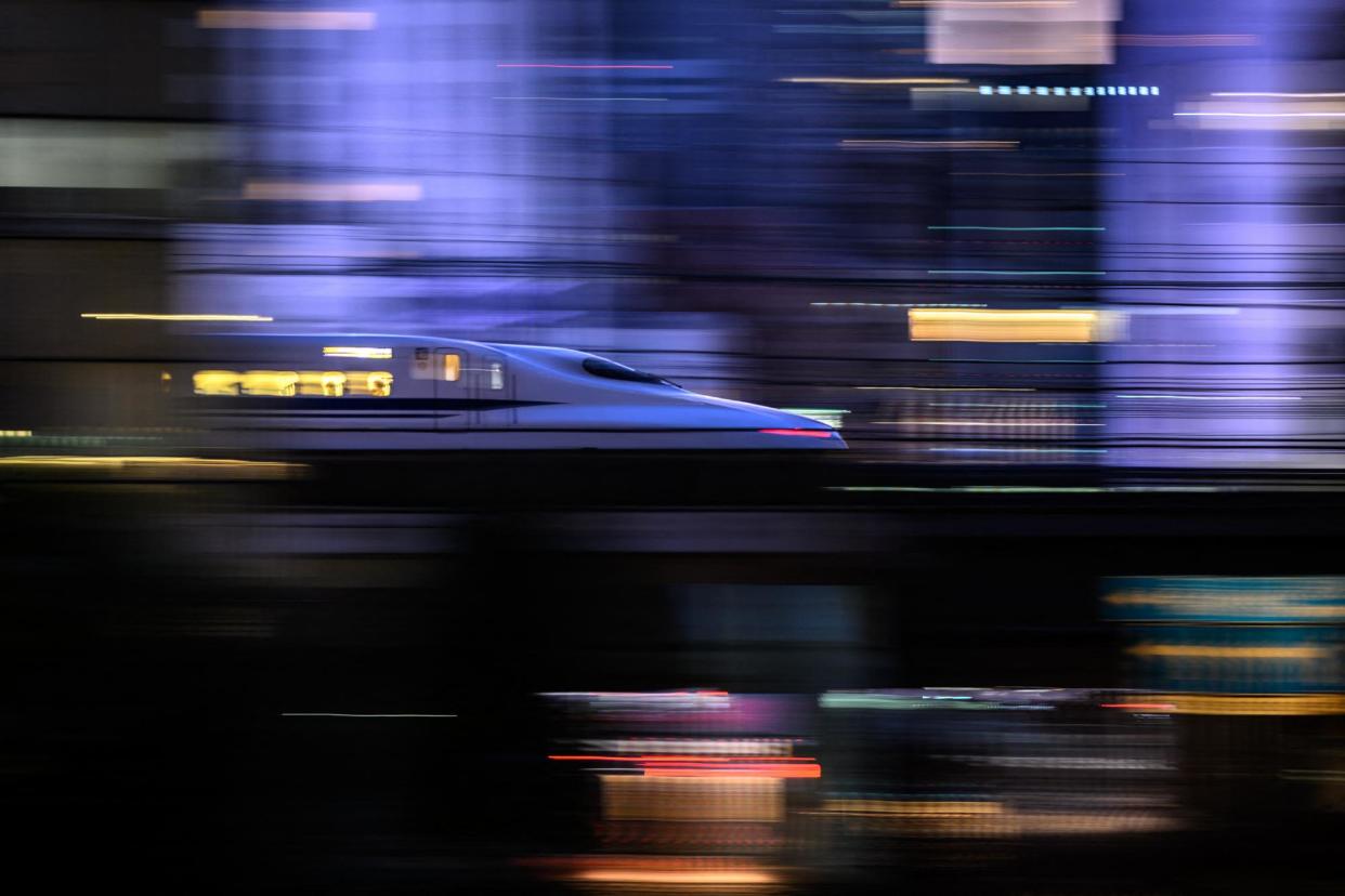 <span>A Tokaido Shinkansen high-speed bullet train passes through Tokyo on 21 January 2024.</span><span>Photograph: Philip Fong/AFP/Getty Images</span>