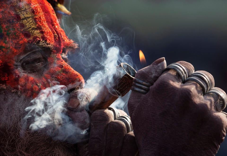 A sadhu, or holy man, smokes marijuana from a clay pipe at the Pashupati Temple in Kathmandu, Nepal, March 4, 2019, during celebrations marking the Hindu festival of Maha Shivaratri. (Photo: Narendra Shrestha/EPA-EFE/REX/Shutterstock) 