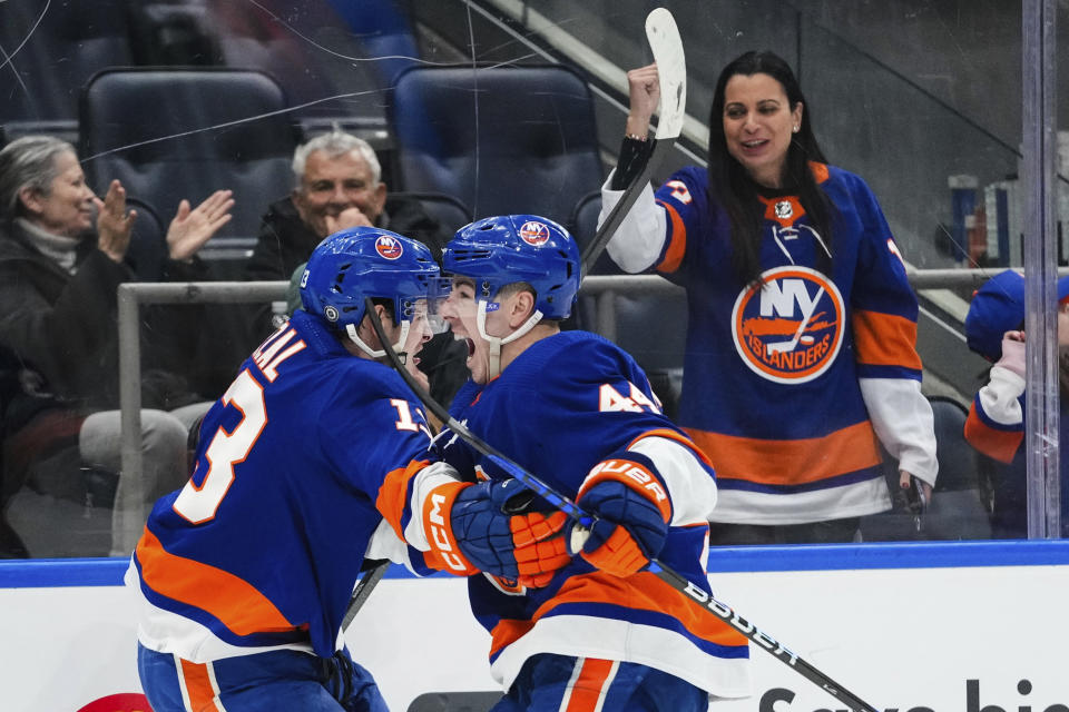 New York Islanders' Jean-Gabriel Pageau, front right, celebrates with Mathew Barzal, left, after Barzal scored during the overtime period of an NHL hockey game against the Toronto Maple Leafs, Thursday, Jan. 11, 2024, in Elmont, N.Y. (AP Photo/Frank Franklin II)