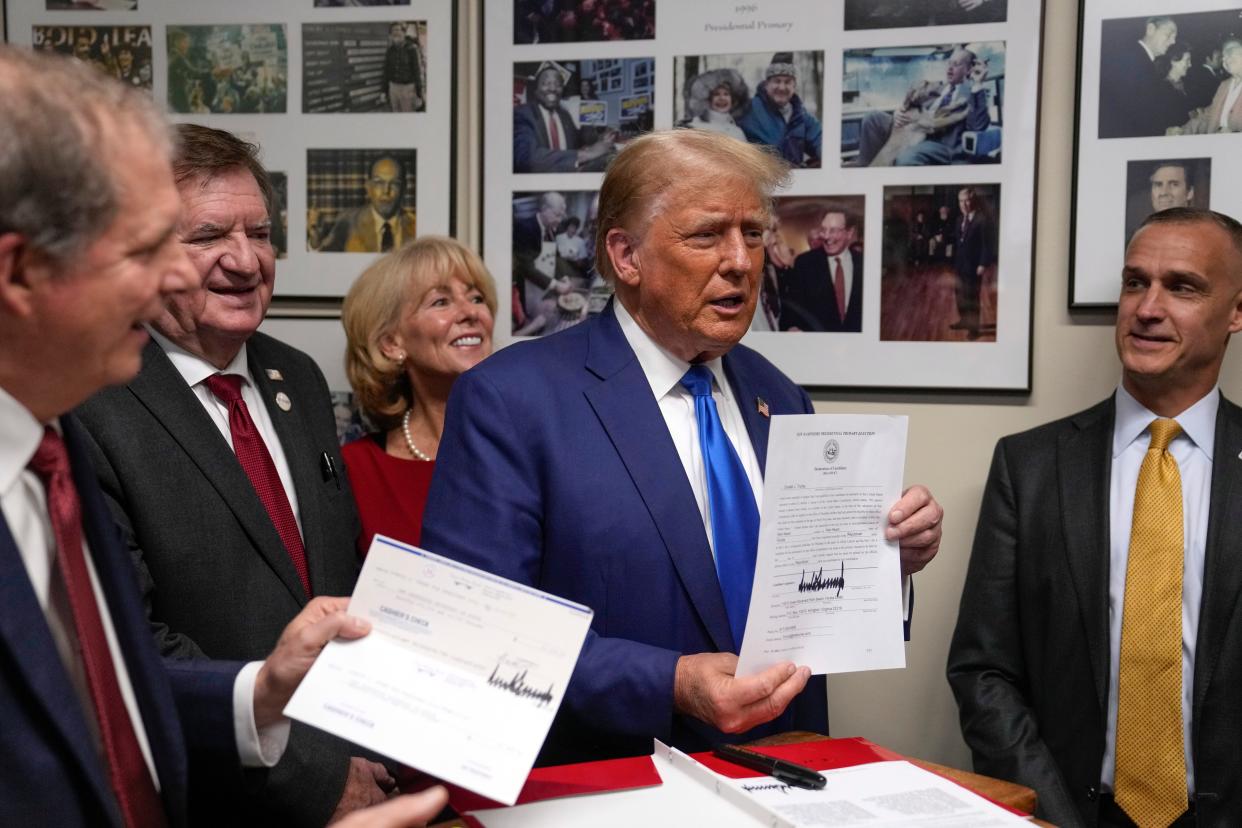 Republican presidential candidate former President Donald Trump talks as New Hampshire Secretary of State David Scanlan, left, listens as he signs papers to be on the 2024 Republican presidential primary ballot at the New Hampshire Statehouse, Monday, Oct. 23, 2023, in Concord. At right is Corey Lewandowski.