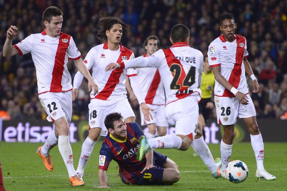 FC Barcelona's Lionel Messi, from Argentina, third left, duels for the ball against Rayo Vallecano's Iago Falque during a Spanish La Liga soccer match at the Camp Nou stadium in Barcelona, Spain, Saturday, Feb. 15, 2014. (AP Photo/Manu Fernandez)