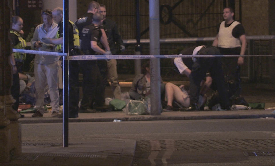 In this image made from PA Video footage, people receive medical attention in Thrale Street near London Bridge following an attack Sunday, June 4, 2017. Terror struck at the heart of London on Saturday night as attackers killed several people in a series of vehicle and knife attacks before police shot them dead. (Federica De Caria/PA via AP)