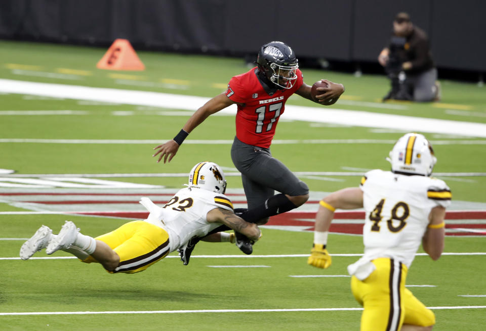 Wyoming linebacker Charles Hicks (33) dives for a tackle on UNLV quarterback Doug Brumfield (17) during the first half of an NCAA college football game in Las Vegas on Friday, Nov. 27, 2020. (Steve Marcus/Las Vegas Sun via AP)