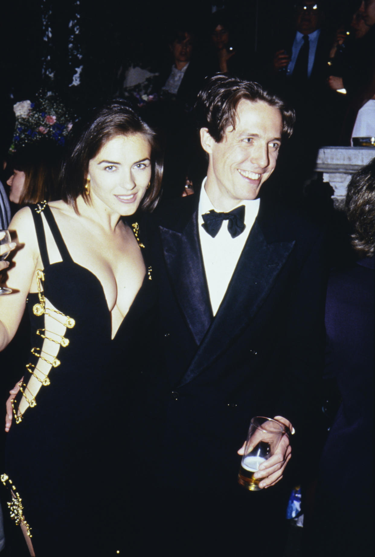 Elizabeth Hurley, famously wearing a Versace dress held together with gold safety pins, and Hugh Grant in 1994 in London. (Photo: Comic Relief/Comic Relief via Getty Images)