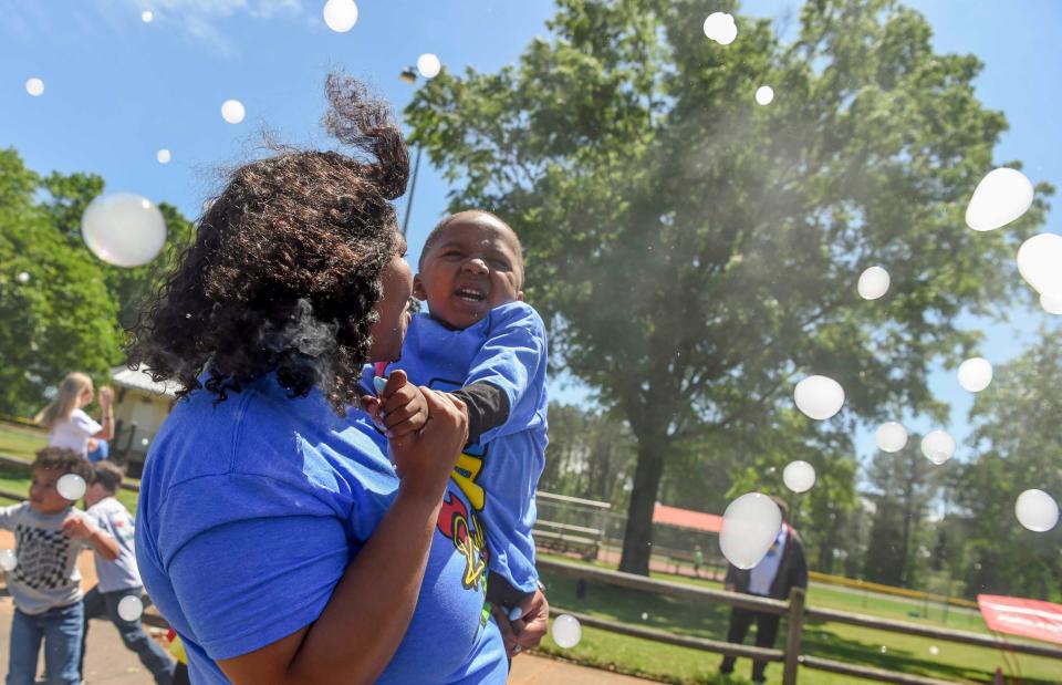 April 21 2024; Tuscaloosa, AL, USA; Kiera Wynn holds Rylan Reedy as they play in a shower of bubbles at the Tuscaloosa Walk for Autism Sunday in Sokol Park. The event hosted by Arts ’n Autism, featured a live DJ, food trucks, vendors, and the walk to raise awareness of autism.