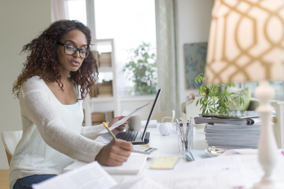 woman sitting at her desk comparing services and taking notes