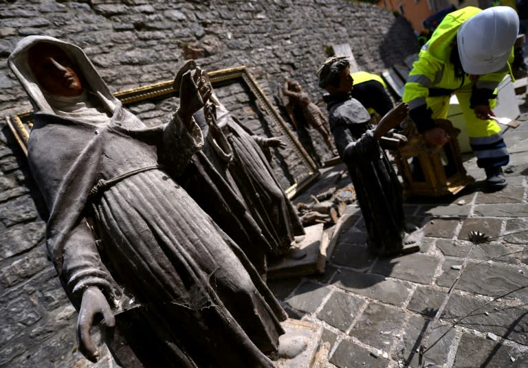 A volunteer on the "blue helmet" brigade to rescue historic artwork cleans statues recovered from the San Francesco di Visso