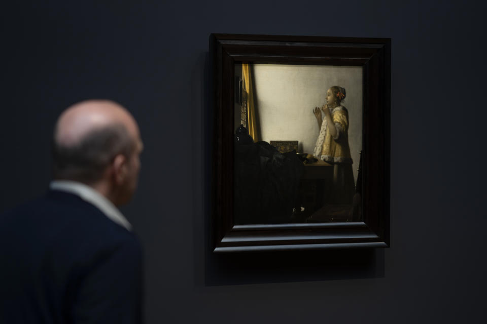 A man looks at Woman with a Pearl Necklace, on loan from Staatliche Museen, Berlin, during a press preview of the Vermeer exhibit at Amsterdam's Rijksmuseum, Monday, Feb. 6, 2023, which unveils its blockbuster exhibition of 28 paintings by 17th-century Dutch master Johannes Vermeer drawn from galleries around the world. (AP Photo/Peter Dejong)