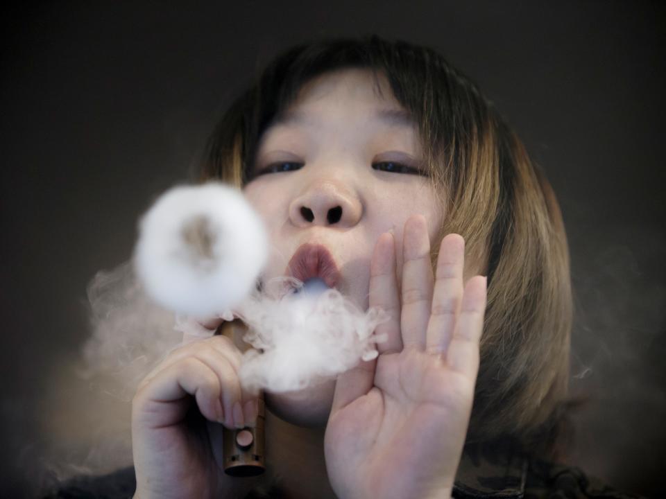 FILE PHOTO: A saleswoman demonstrates vaping at the Vape Shop that sells e-cigarette products in Beijing, China January 30, 2019. REUTERS/Thomas Peter