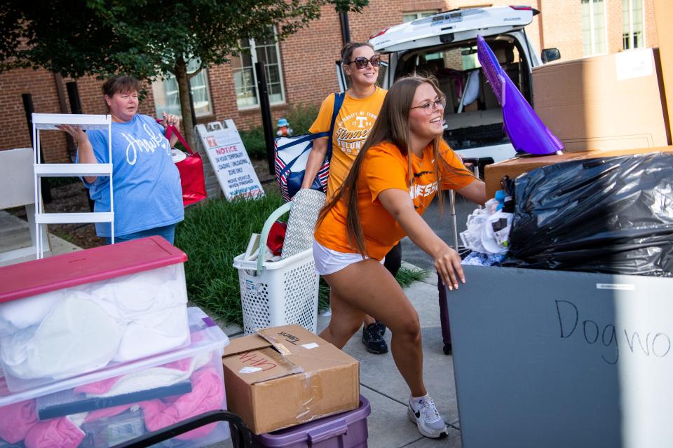 University of Tennessee freshman Evie Phillips, right, pushes a cart full of belongings into her new dorm during move-in day on Wednesday, August 16, 2023.