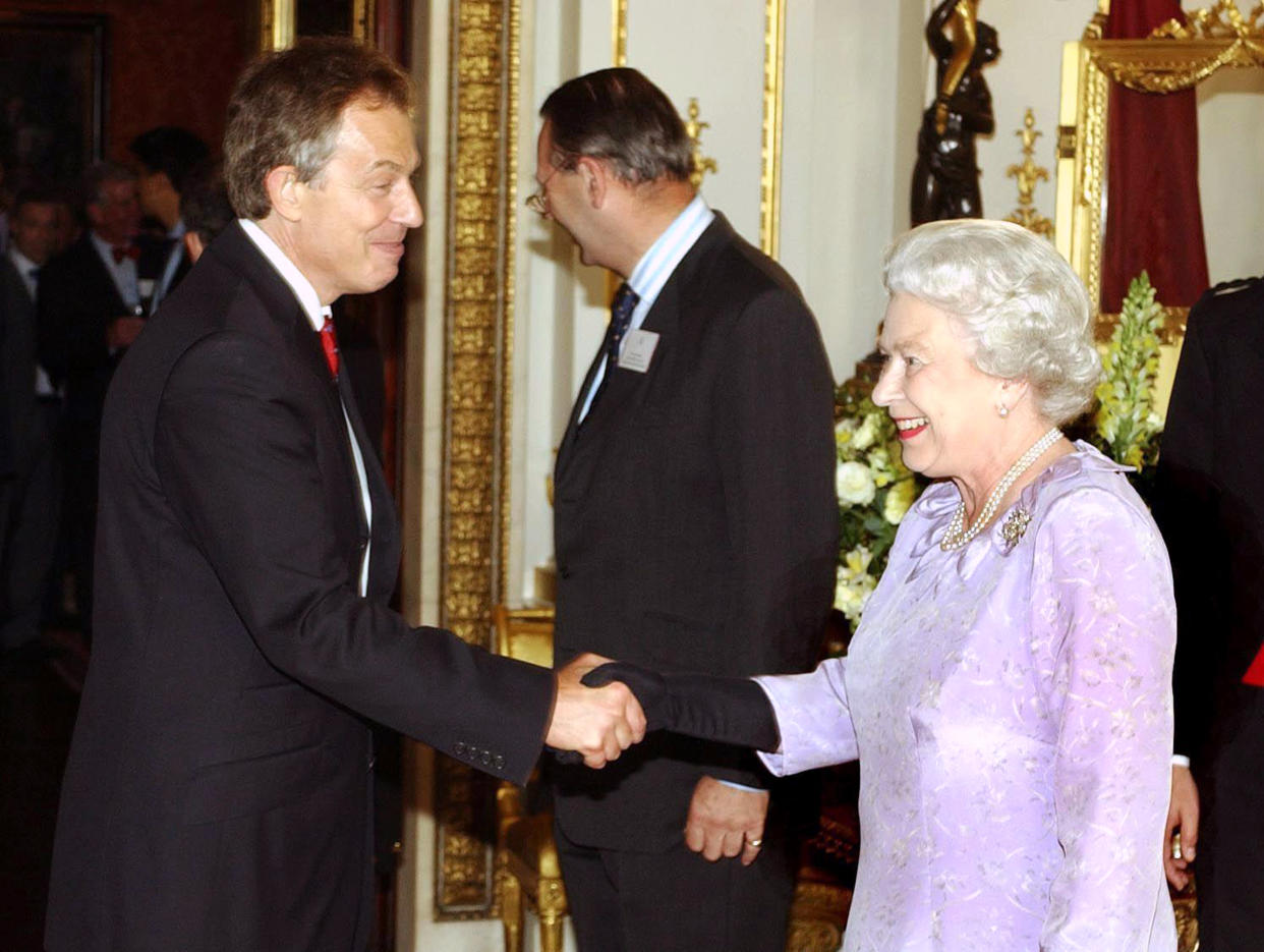 Queen Elizabeth II greeting Prime Minister Tony Blair as he arrives at a reception for The Queen's Award for Enterprise at Buckingham Palace in central London in July 2004. (PA)