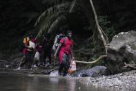 Migrants cross the Acandi River on their way north, in Acandi, Colombia, Wednesday, Sept. 15, 2021. The migrants, following a well-beaten, multi-nation journey towards the U.S., will continue their journey through the jungle known as the Darien Gap. (AP Photo/Fernando Vergara)