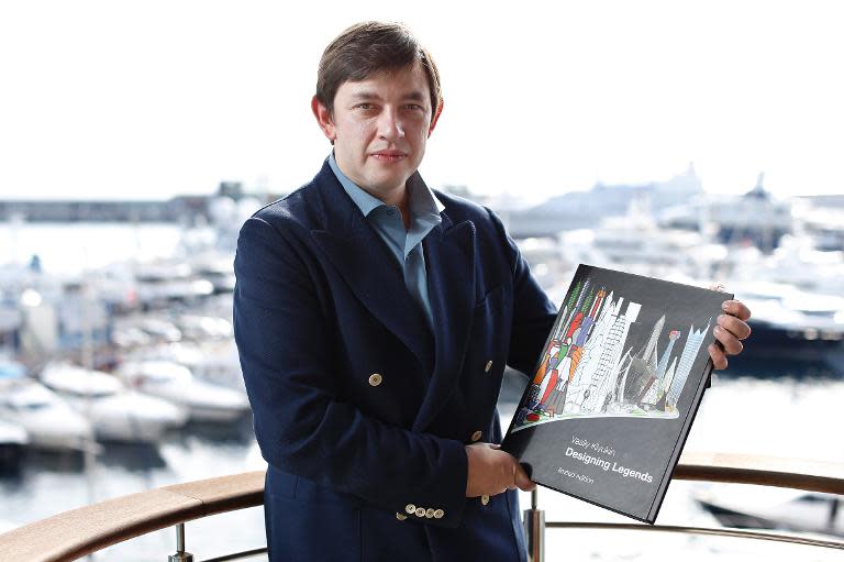 Russian millionaire Vasily Klyukin poses for a photo at home, with his book, in Monaco, on October 25, 2013