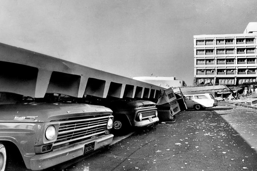 Vehicles are crushed by a fallen structure after the magnitude-6.6 Sylmar earthquake on Feb. 9, 1971. <span class="copyright">(Boris Yaro / Los Angeles Times)</span>