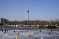 Residents skate on a frozen lake in Beijing, China, Tuesday, Jan. 11, 2022. The Chinese capital is on high alert ahead of the Winter Olympics as China locks down a third city elsewhere for COVID-19 outbreak. (AP Photo/Ng Han Guan)