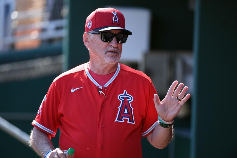 Angels manager Joe Maddon speaks with players in the dugout.