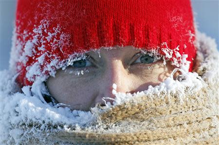 Ice from the breath of Gail Davis forms around her face as she exercises by walking outside in Minneapolis, January 8, 2014. REUTERS/Eric Miller