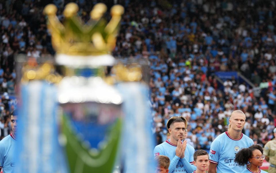 Erling Haaland of Manchester City glances towards the Premier League trophy - GETTY IMAGES