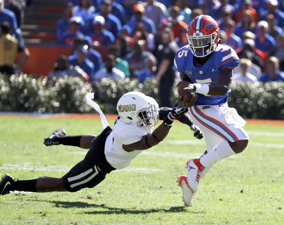 Florida quarterback Emory Jones, right, scrambles from the pocket as he tries to get past Idaho defensive back Tyrese Dedmon, left, during the first half of an NCAA college football game, Saturday, Nov. 17, 2018, in Gainesville, Fla. (AP Photo/John Raoux)