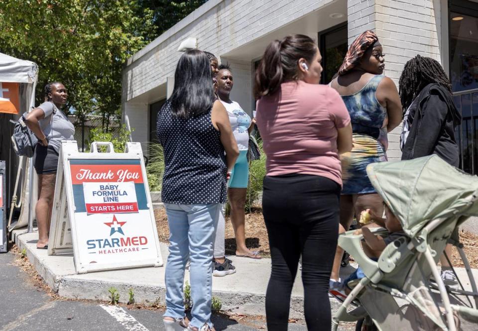 People wait in line for free baby formula at StarMed Healthcare.