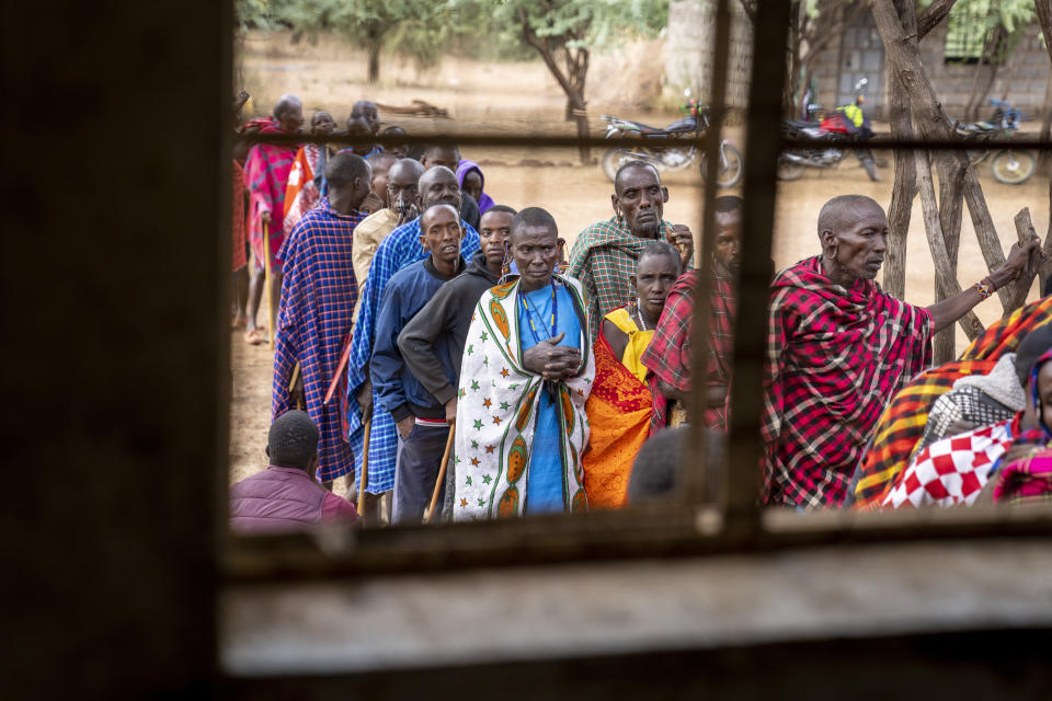 Maasai wait in line to cast their votes in the general election at a polling station in Esonorua Primary School, in Kajiado County, Kenya Tuesday, Aug. 9, 2022. Polls opened Tuesday in Kenya's unusual presidential election, where a longtime opposition leader who is backed by the outgoing president faces the deputy president who styles himself as the outsider. (AP Photo/Ben Curtis)