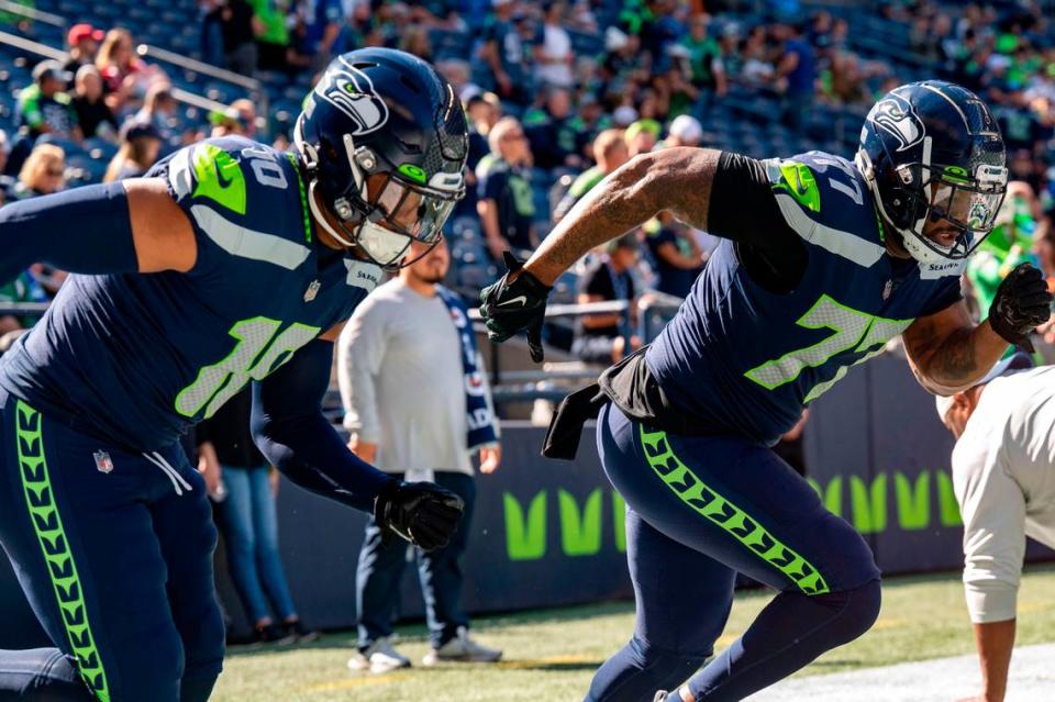 Seattle Seahawks defensive tackle Quinton Jefferson (77) and linebacker Uchenna Nwosu (10) sprint during warm ups prior to the start of an NFL game against the Atlanta Falcons on Sunday, Sept. 25, 2022, at Lumen Field in Seattle.