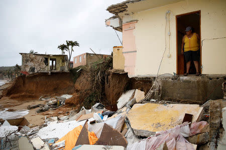 Yamary Morales looks at the damage at a neighbor's house after the area was hit by Hurricane Maria in Yabucoa, Puerto Rico September 22, 2017. REUTERS/Carlos Garcia Rawlins