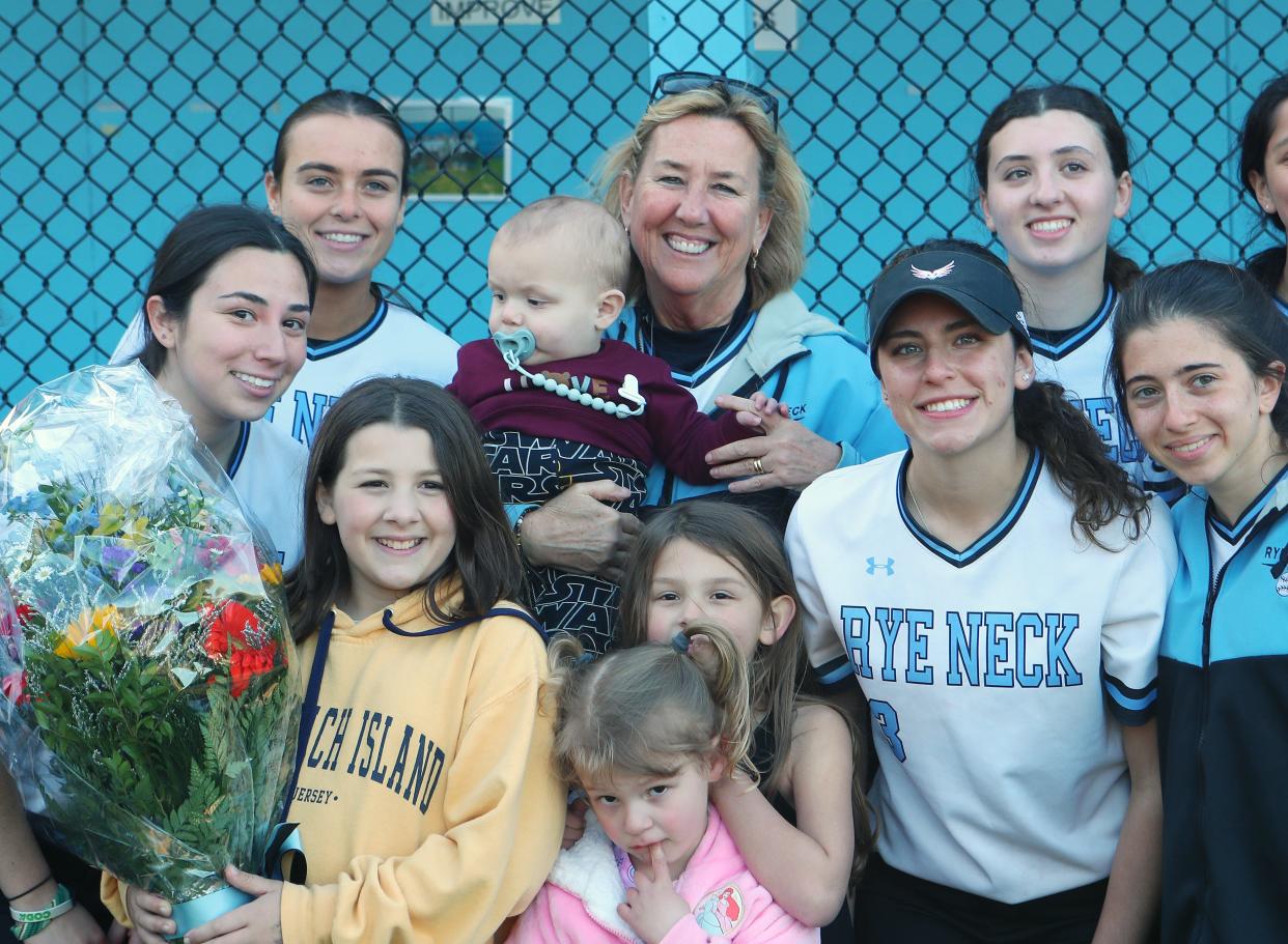 Rye Neck softball coach Joan Spedafino is surrounded by her family and players after Rye Neck defeated Westlake for her 600th career win at Rye Neck High School April 26, 2024.