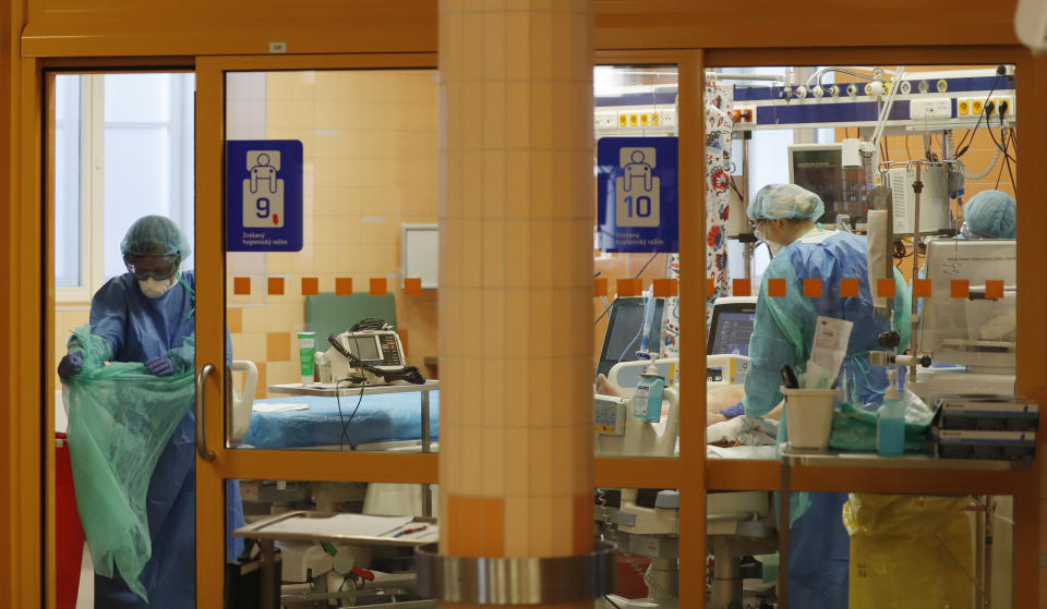 Healthcare workers attend to a COVID-19 patient at an intensive care unit (ICU) at the General University Hospital in Prague, Czech Republic, Tuesday, April 7, 2020. The new coronavirus causes mild or moderate symptoms for most people, but for some, especially older adults and people with existing health problems, it can cause more severe illness or death. (AP Photo/Petr David Josek)