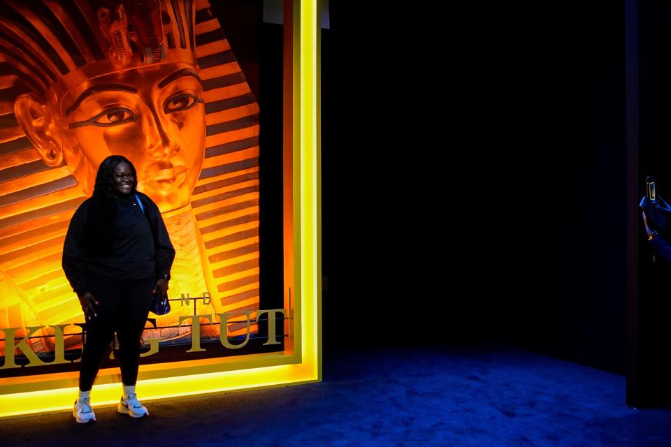 A person poses for a photo in front a large replica of National Geographic's Sept. 2010 magazine cover at the Beyond King Tut Immersive Experience, Thursday, Oct. 27, 2022, in New York. The exhibition will open to the public on Friday, in commemoration of the the 100th anniversary of the discovery of King Tut's tomb on Nov. 4, 1922. (AP Photo/Julia Nikhinson)
