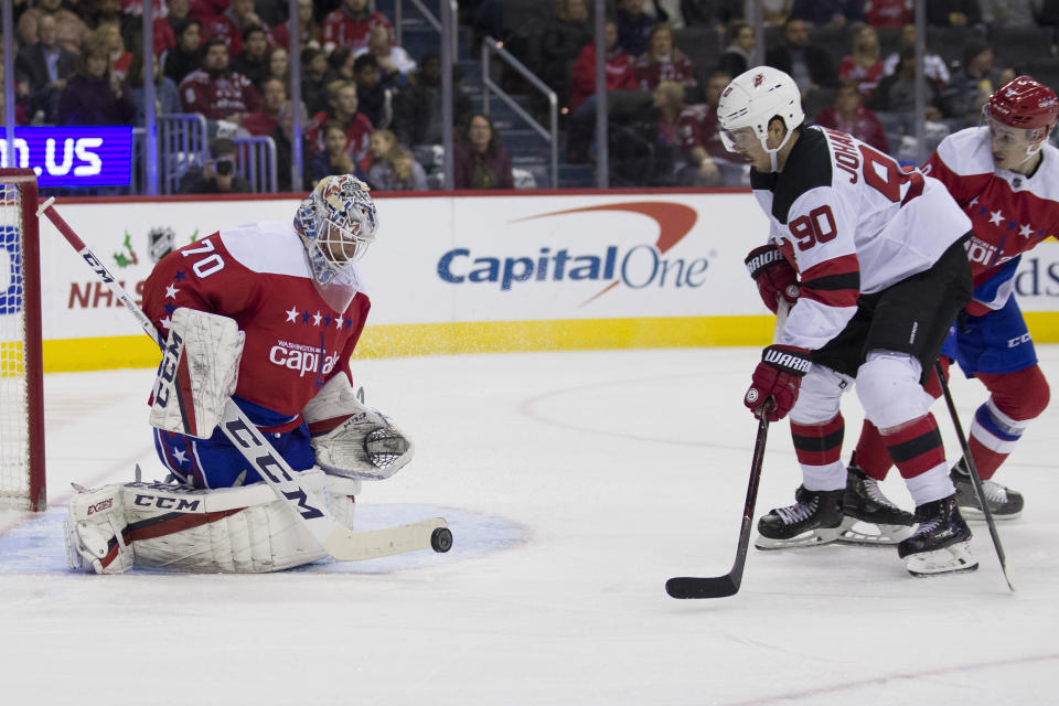 Washington Capitals goaltender Braden Holtby (70) blocks a shot by New Jersey Devils left wing Marcus Johansson (90), from Sweden, during the second period of an NHL hockey game Friday, Nov. 30, 2018, in Washington. (AP Photo/Alex Brandon)