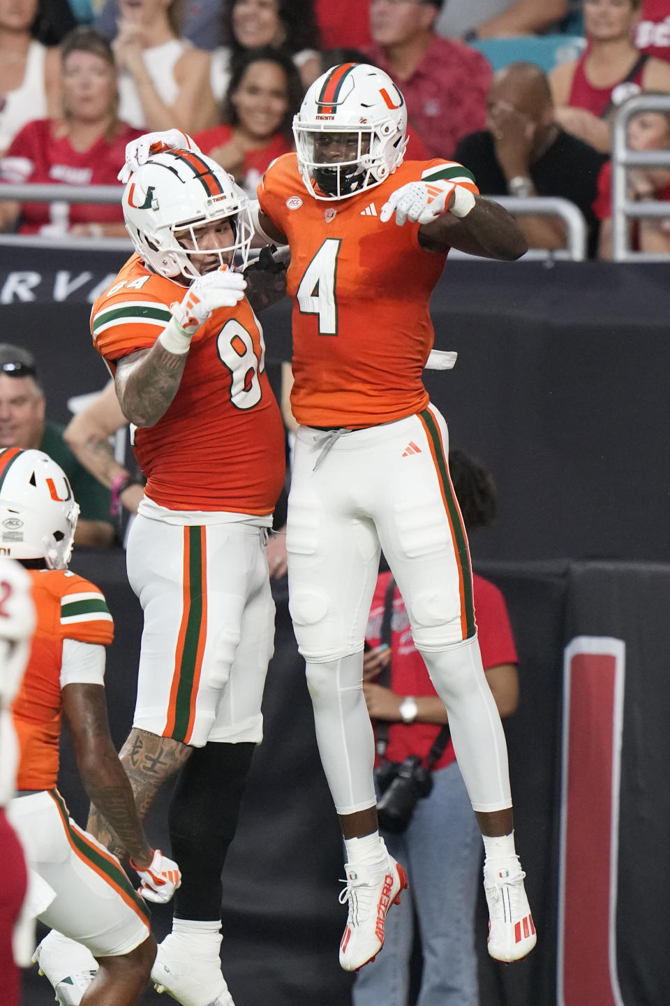 FILE - Miami wide receiver Colbie Young, right, celebrates his touchdown run with tight end Cam McCormick (84) during the first half of an NCAA college football game against Miami (Ohio), Friday, Sept. 1, 2023, in Miami Gardens, Fla. Cam McCormick enrolled in college in 2016. He might still be there in 2025. The Miami tight end announced Thursday, Jan. 17, 2024, that he will return to college for what is believed to be an unprecedented ninth season of eligibility, getting one final season from a career that was derailed multiple times by season-ending injuries.(AP Photo/Wilfredo Lee, File)