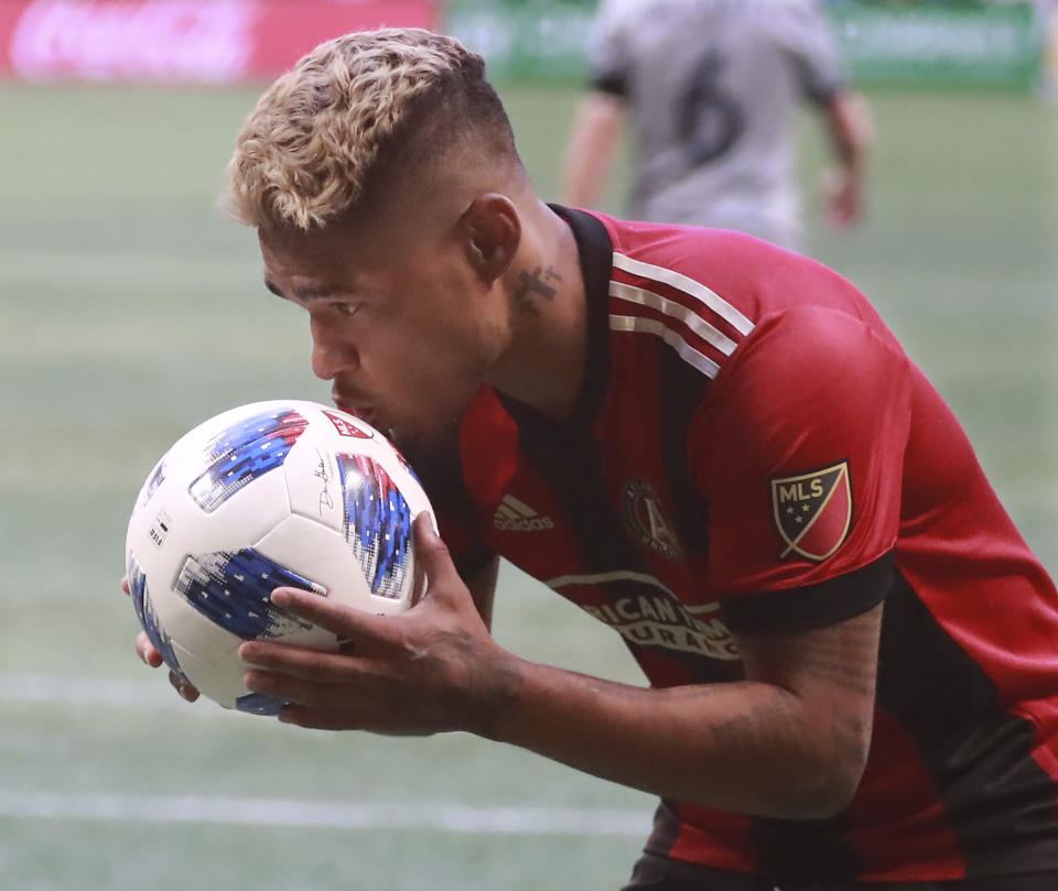 Atlanta United forward Josef Martinez kisses the ball while celebrating a goal by teammate Chris McCann for a lead over the Chicago Fire during the first half of an MLS soccer match on Sunday, Oct. 21, 2018, in Atlanta. (Curtis Compton/Atlanta Journal-Constitution via AP)