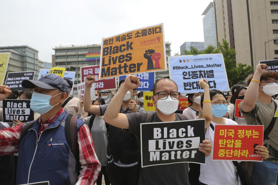 South Korean protesters shout slogans during a protest over the death of George Floyd, a black man who died after being restrained by Minneapolis police officers on May 25, near the U.S. embassy in Seoul, South Korea, Friday, June 5, 2020. The signs read "The U.S. government should stop oppression and there is no peace without justice." (AP Photo/Ahn Young-joon)