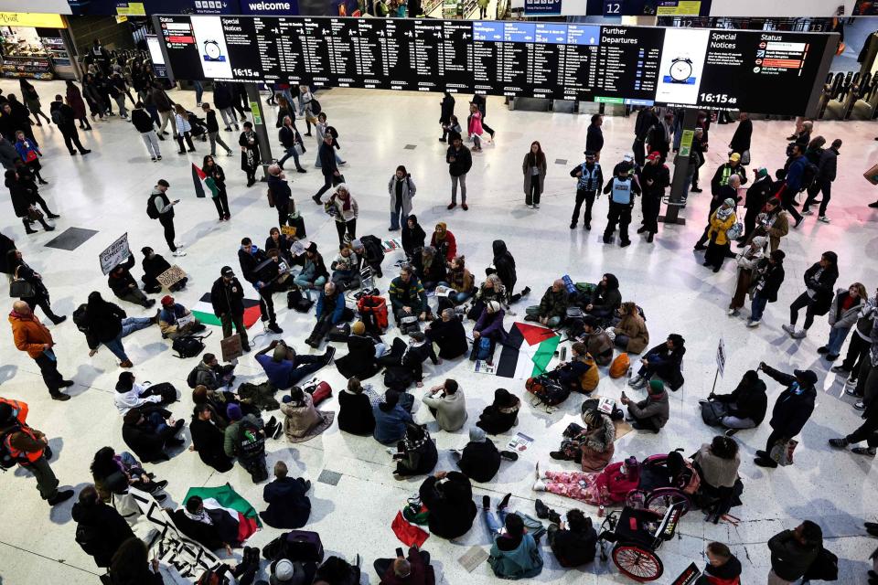 Protesters take part in a sit-in protest at Waterloo Station on Saturday (AFP via Getty Images)