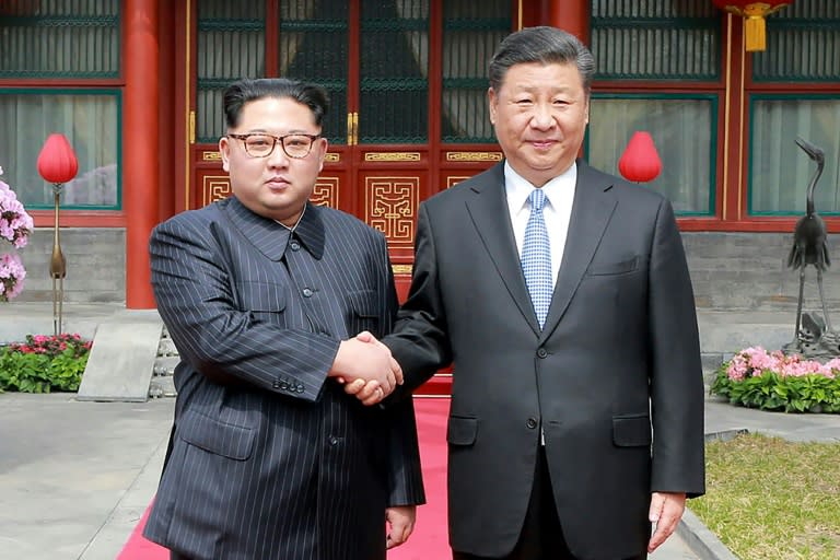 Kim and Xi shake hands during his fence-mending trip to Beijing